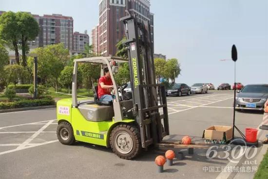 參賽選手駕駛中聯(lián)重科叉車進(jìn)行“投籃”項(xiàng)目
