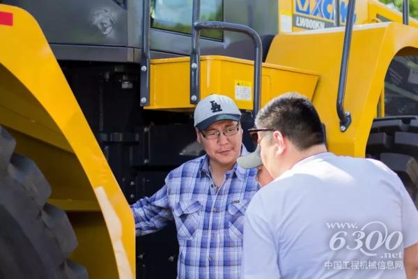 客戶仔細(xì)觀察裝載機(jī)，并不斷向工作人員詢問其性能參數(shù)